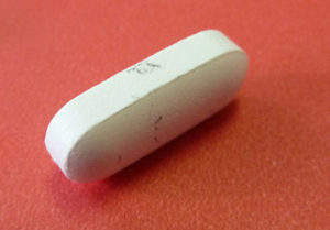 Foreign material on a pill, as analyzed at EAG Laboratories
